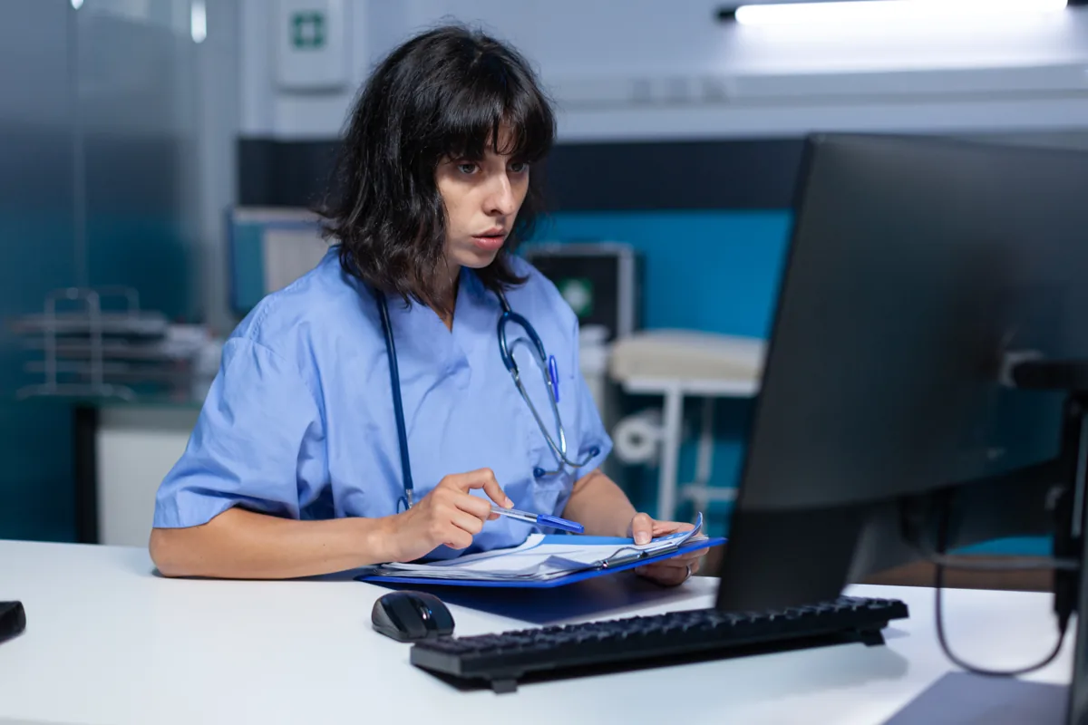 A healthcare professional reviewing sensitive records data securely on a monitor