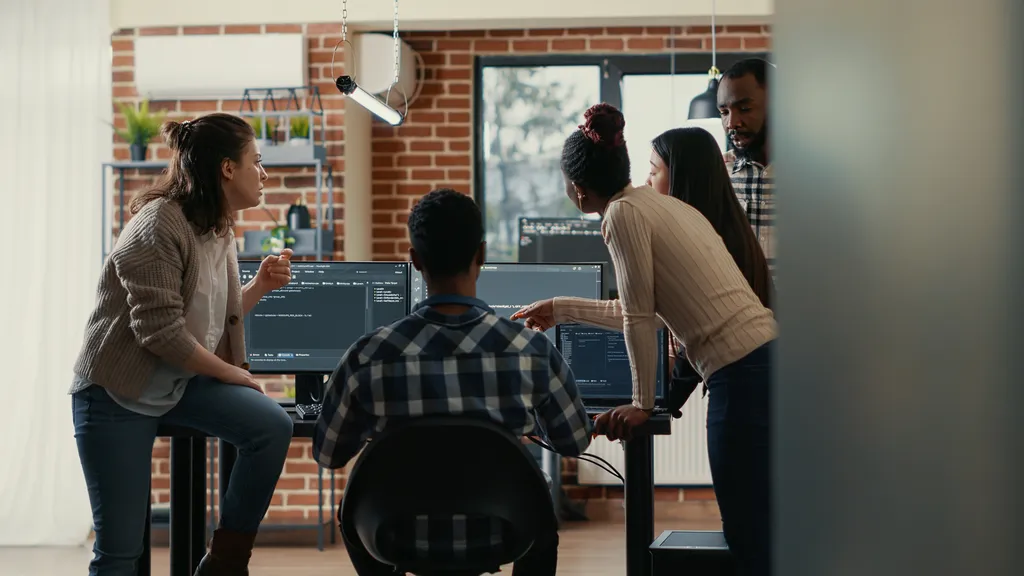 Software team reviewing code across multiple screens to catch errors during automated E2E testing