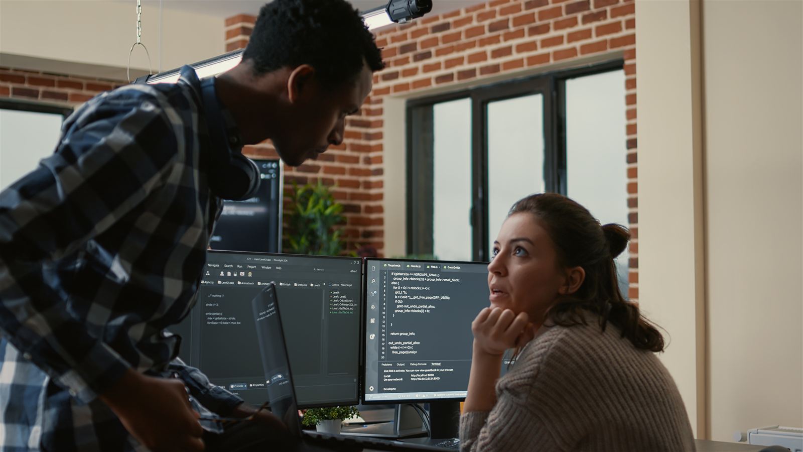 Two developers reviewing source code together to trace a test failure back to its root cause