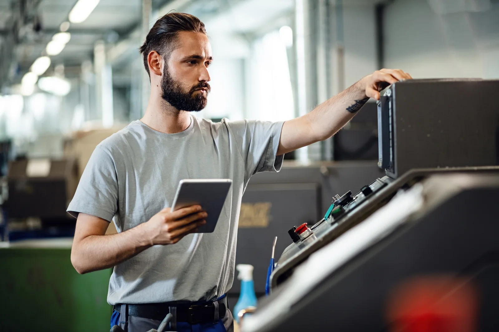 Manufacturing engineer using a tablet to review ERP test data on the factory floor